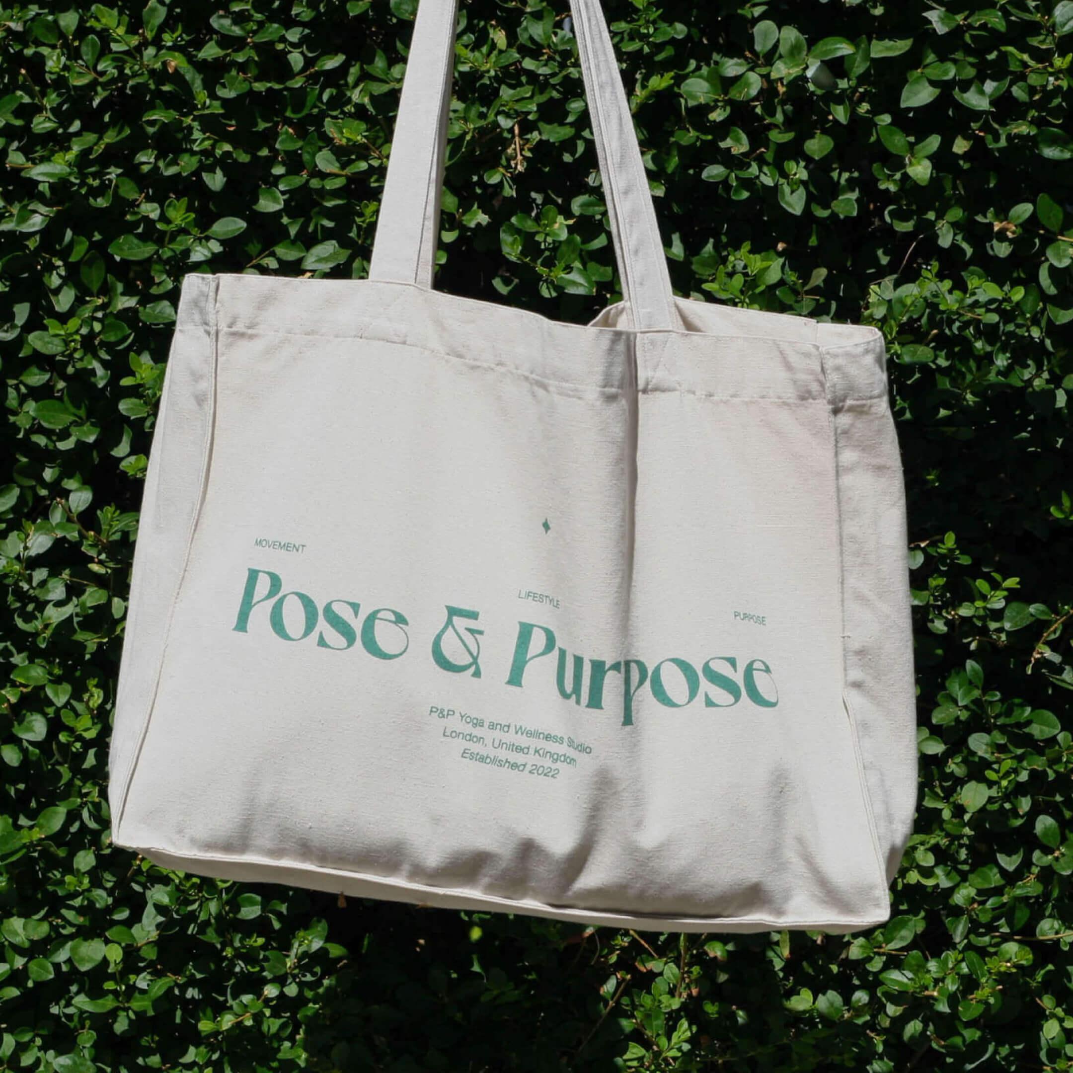 Photo of Pose & Purpose tote bag held behind against blue sky