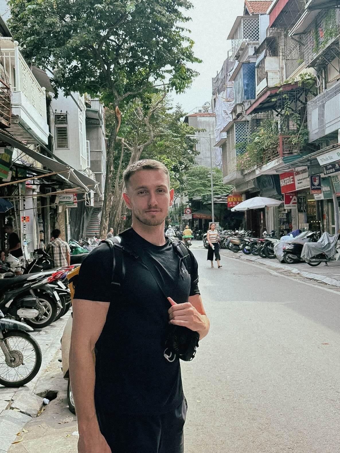 Photo of Ryan stood on a street in Hanoi, Vietnam.