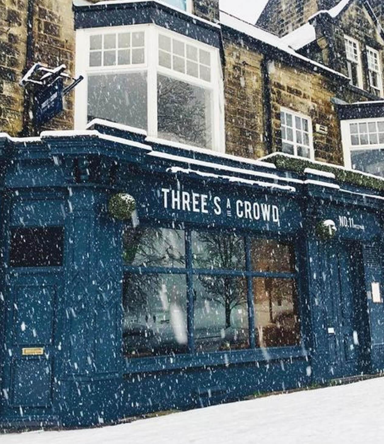 Three's A Crowd storefront in snow